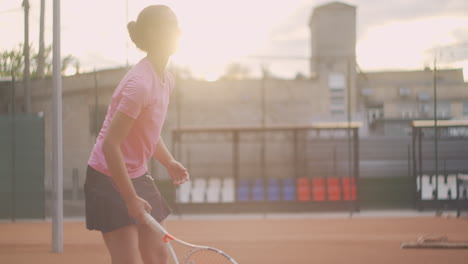 Eine-Tennisspielerin-Auf-Dem-Platz-Schlägt-In-Zeitlupe-Einen-Ball-In-Die-Sonne